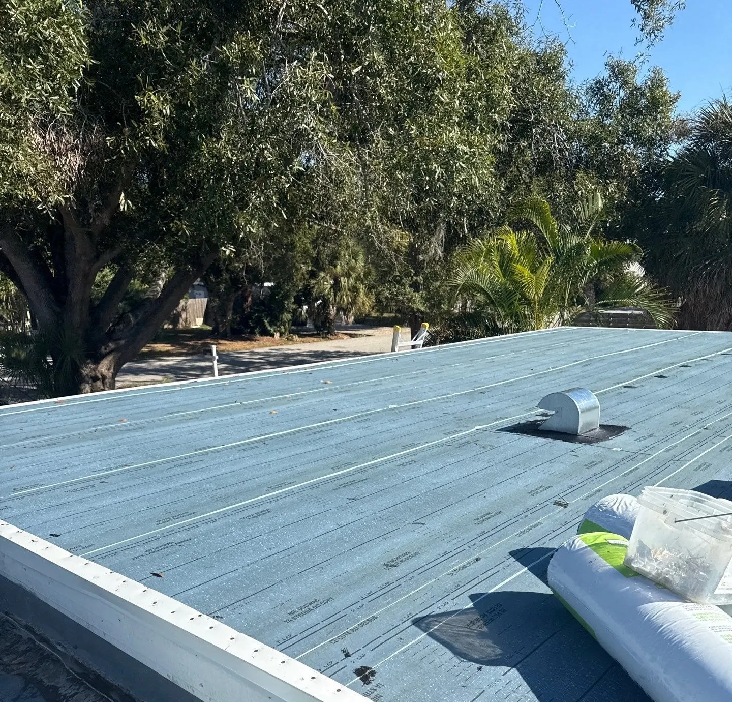 New white edge metal and roof vent on a flat roof re-roof in Sarasota