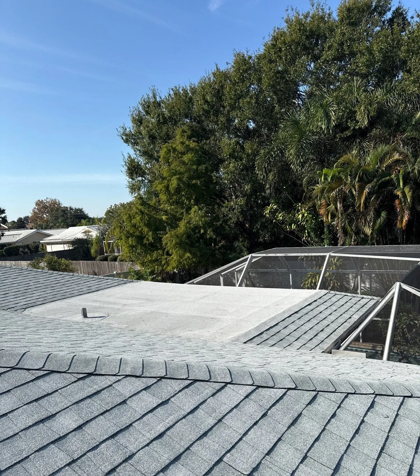 New light-gray architectural shingle and finished flat section on the same Sarasota home after the re-roof